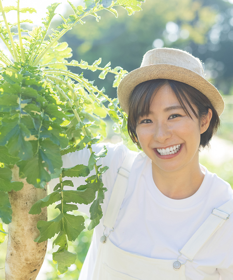 新鮮な大根を手に持ち笑顔の女性